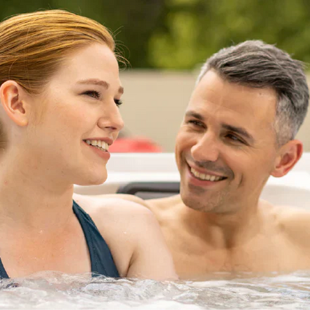couple sitting close in hot tub after applying hth spa scale preventer