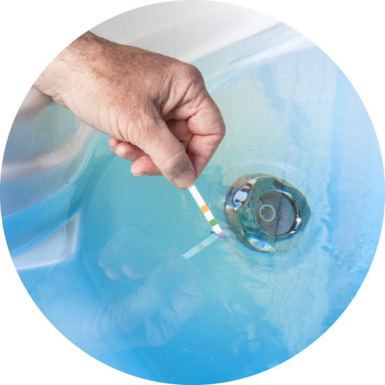 man dipping hth hot tub test strip into hot tub to test hot tub water